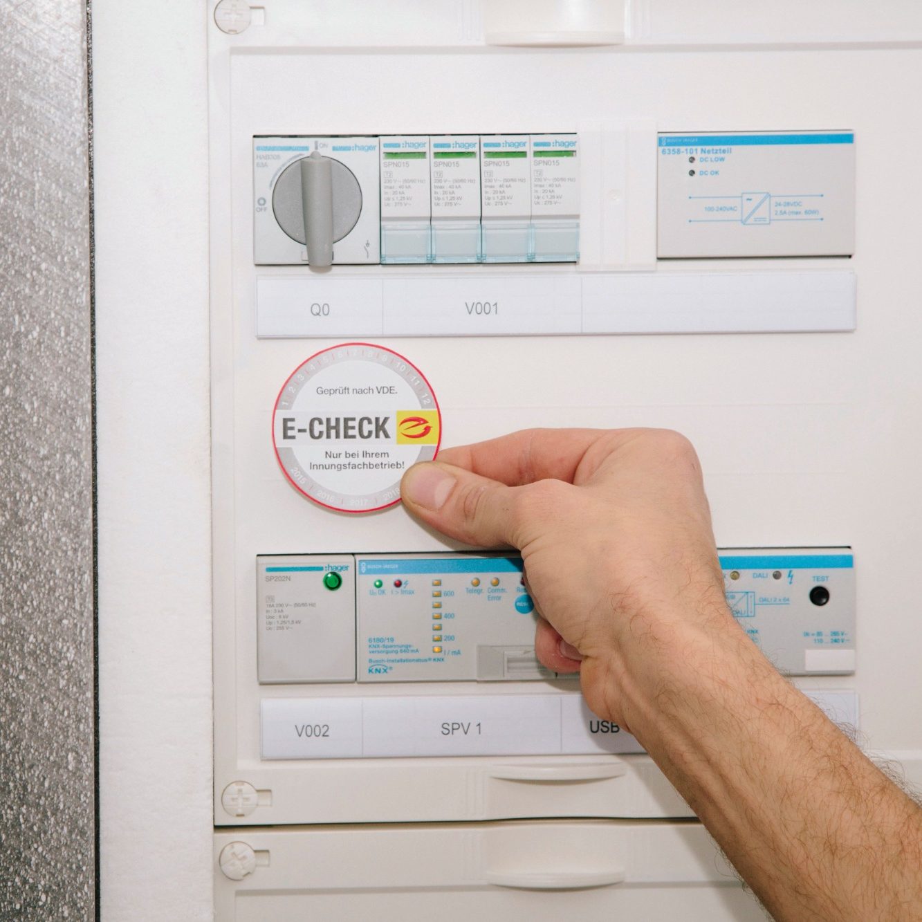 Hand führt einen E CHECK an einem Prüfgerät durch, um elektrische Anlagen fachgerecht zu kontrollieren und die Sicherheit beim Kunden zu gew