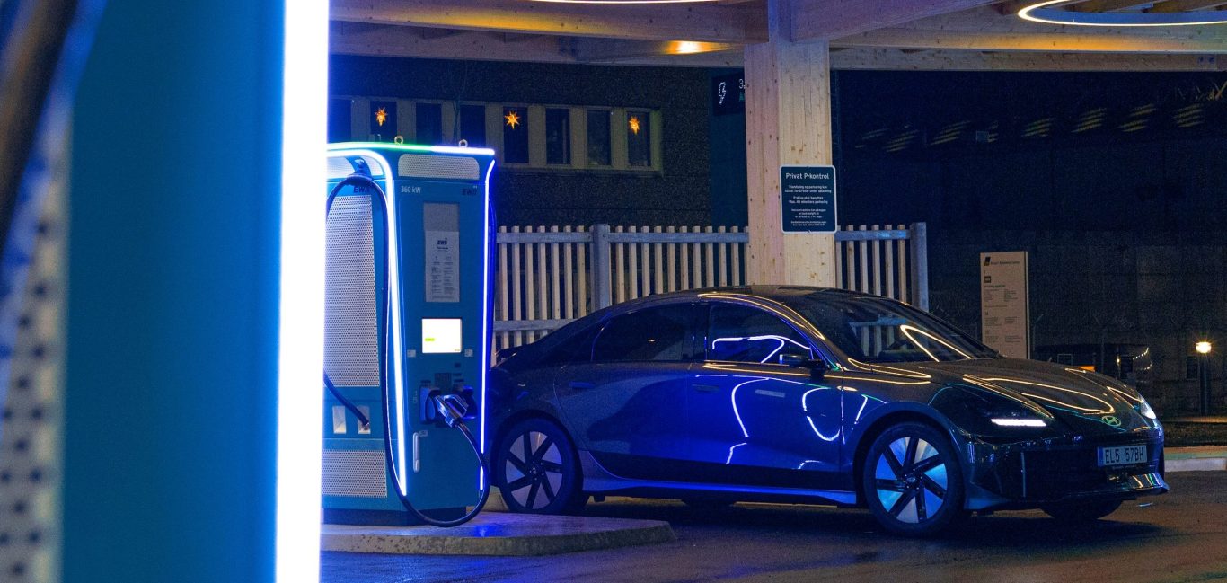 Elektrofahrzeug lädt nachts an einer modernen Ladestation